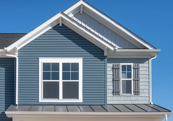 Exterior view of a house with blue siding and white trim. 