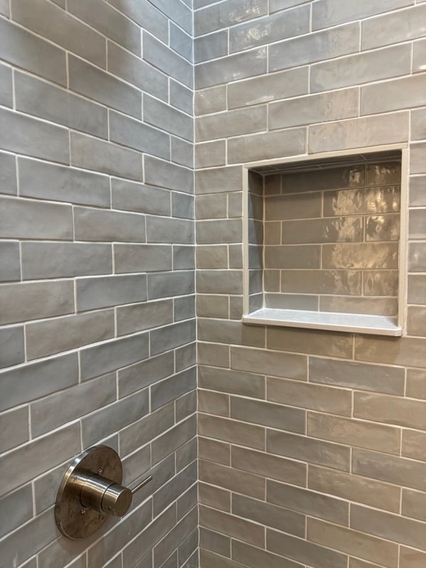 Close up of subway tile and inset shelving in glossy walk in shower in Athens, GA