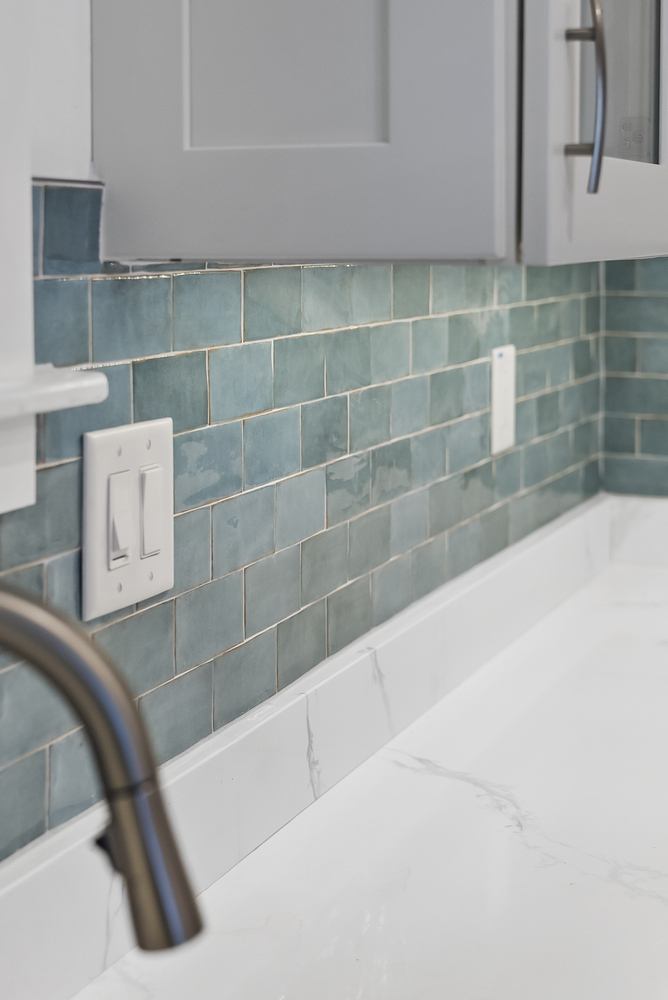 Close-up of teal tile backsplash and quartz counter from a Bishop, GA kitchen remodel by Encompass Contracting