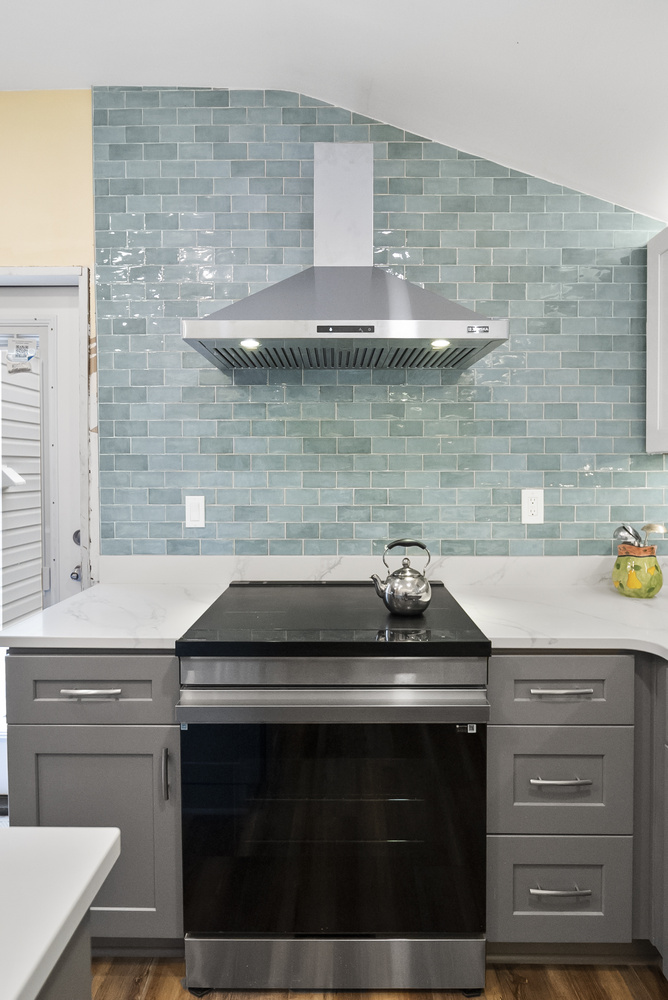 Modern stove and range hood in remodeled Statham, GA kitchen by Encompass Contracting