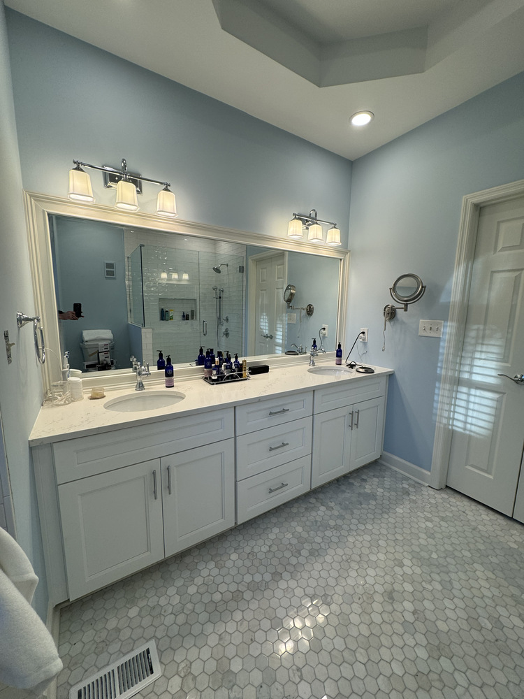 Custom double vanity remodel in Watkinsville, GA by Encompass Contracting with large mirror and modern lighting