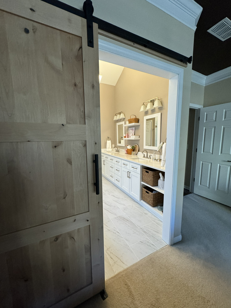 Entry view into remodeled master bathroom in Athens, GA with sliding barn door by Encompass Contracting