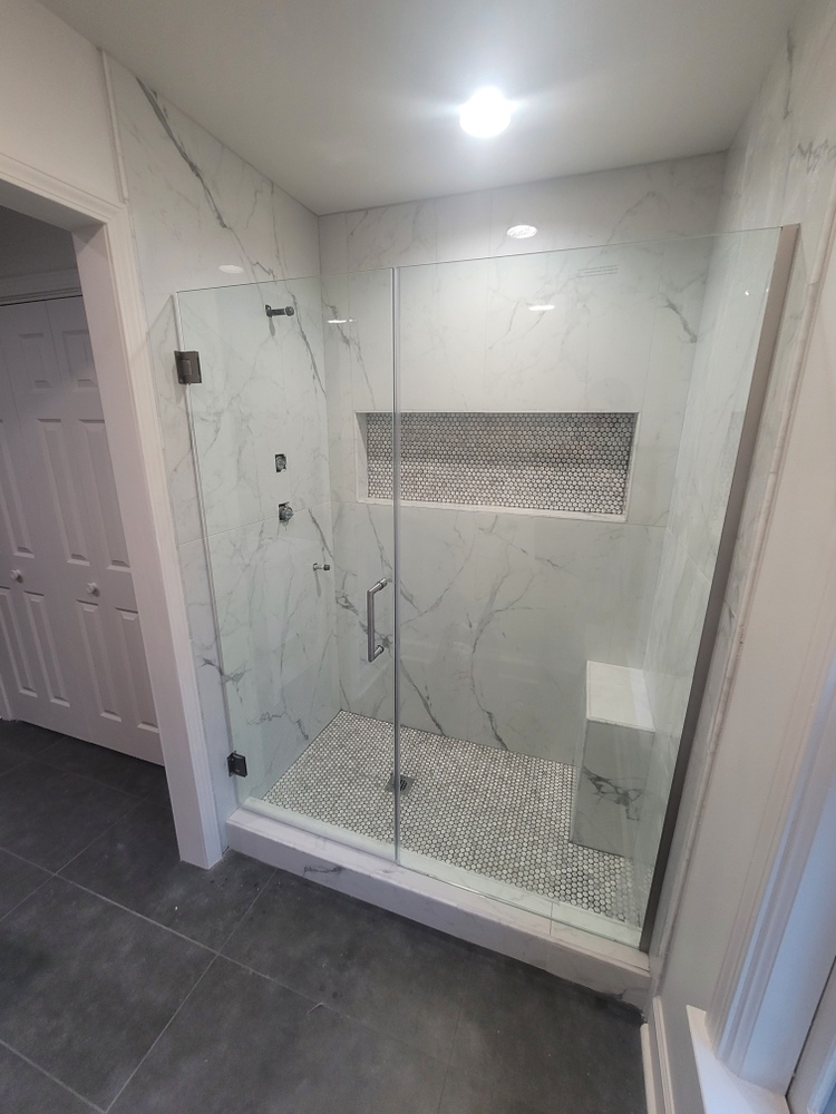 Glass shower remodel with marble walls and mosaic floor in Athens, GA by Encompass Contracting