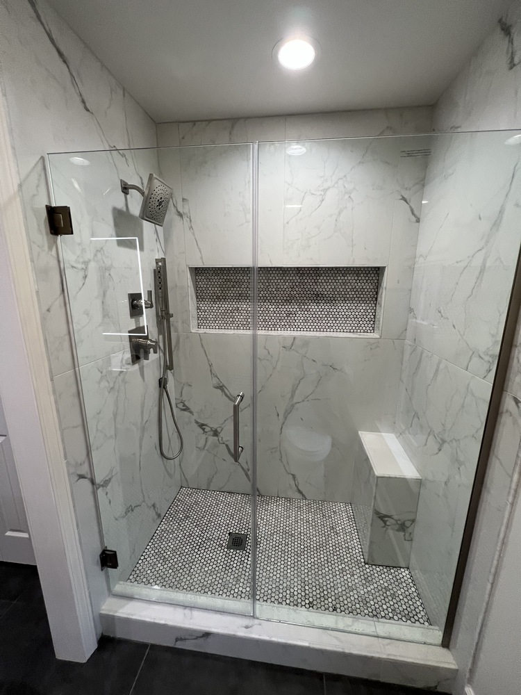 Modern glass shower remodel with marble tile in Athens bathroom by Encompass Contracting