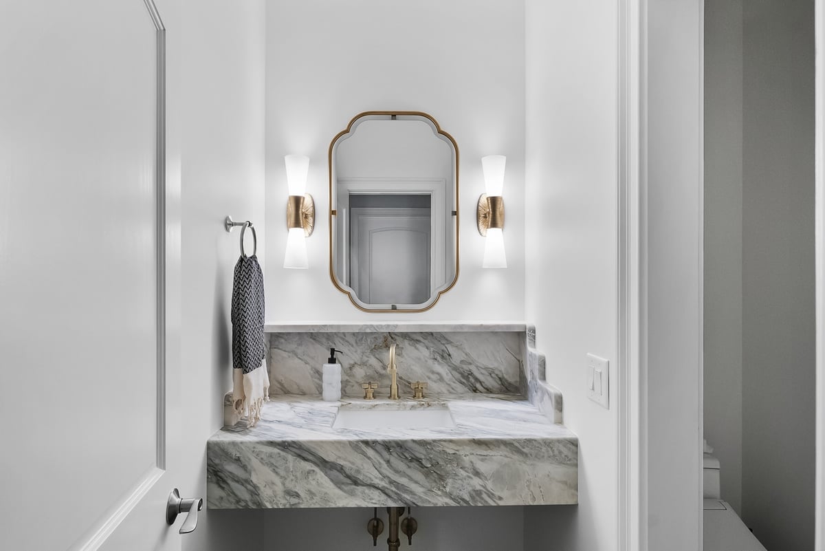 Brookhaven powder room remodel with marble countertop and gold faucet by Encompass Contracting