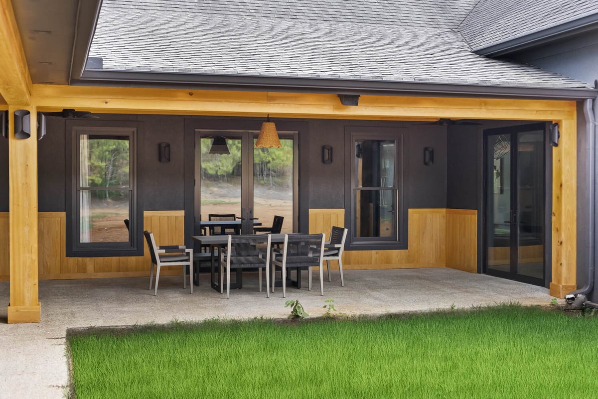 Covered patio with outdoor dining area in Brookhaven whole home remodel by Encompass Contracting
