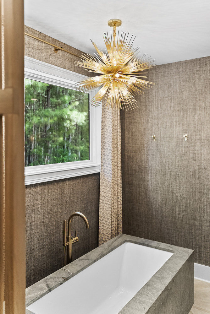 Freestanding tub with modern chandelier in Brookhaven bathroom remodel by Encompass Contracting
