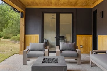A covered patio attached to a single family home in Athens, GA, with outdoor chairs and a fire pit 