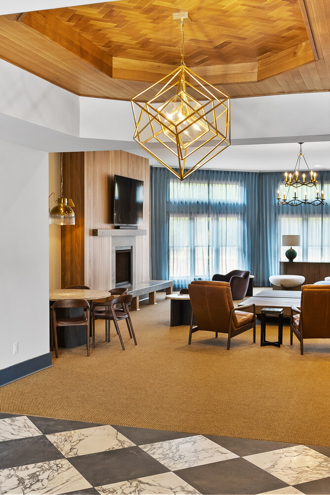 Spacious living room with wood ceiling and modern chandelier in Brookhaven remodel by Encompass Contracting
