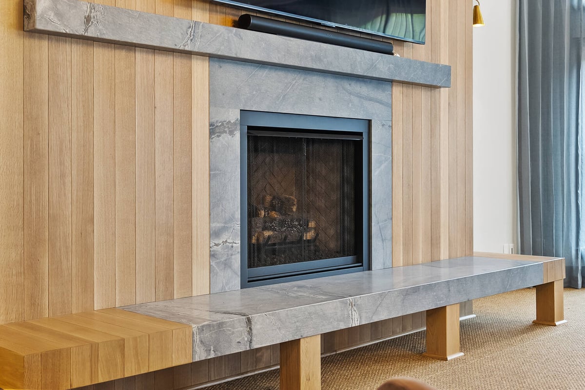 Stone and wood fireplace design in Brookhaven whole home remodel by Encompass Contracting