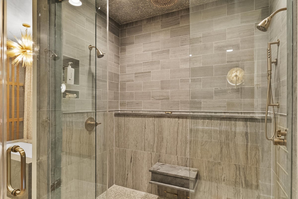 Walk-in glass shower with tile and built-in bench in Brookhaven bathroom remodel by Encompass Contracting