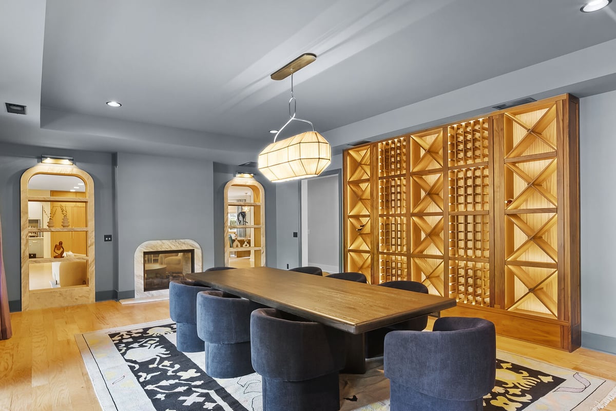 Wine room with custom wood shelving and modern lighting in Brookhaven remodel by Encompass Contracting