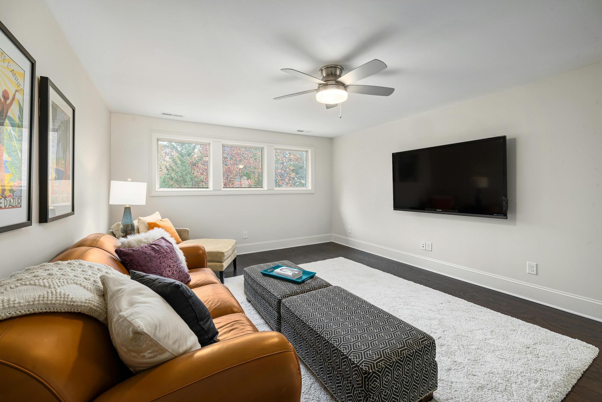 Basement living room remodel with leather sofa by Encompass Contracting in Athens, GA - stock