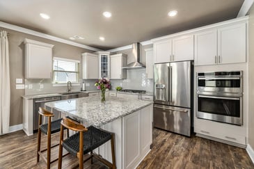 A remodeled kitchen in a single-family home in Athens, Georgia, with an open layout design, stainless steel appliances, and marble countertops.