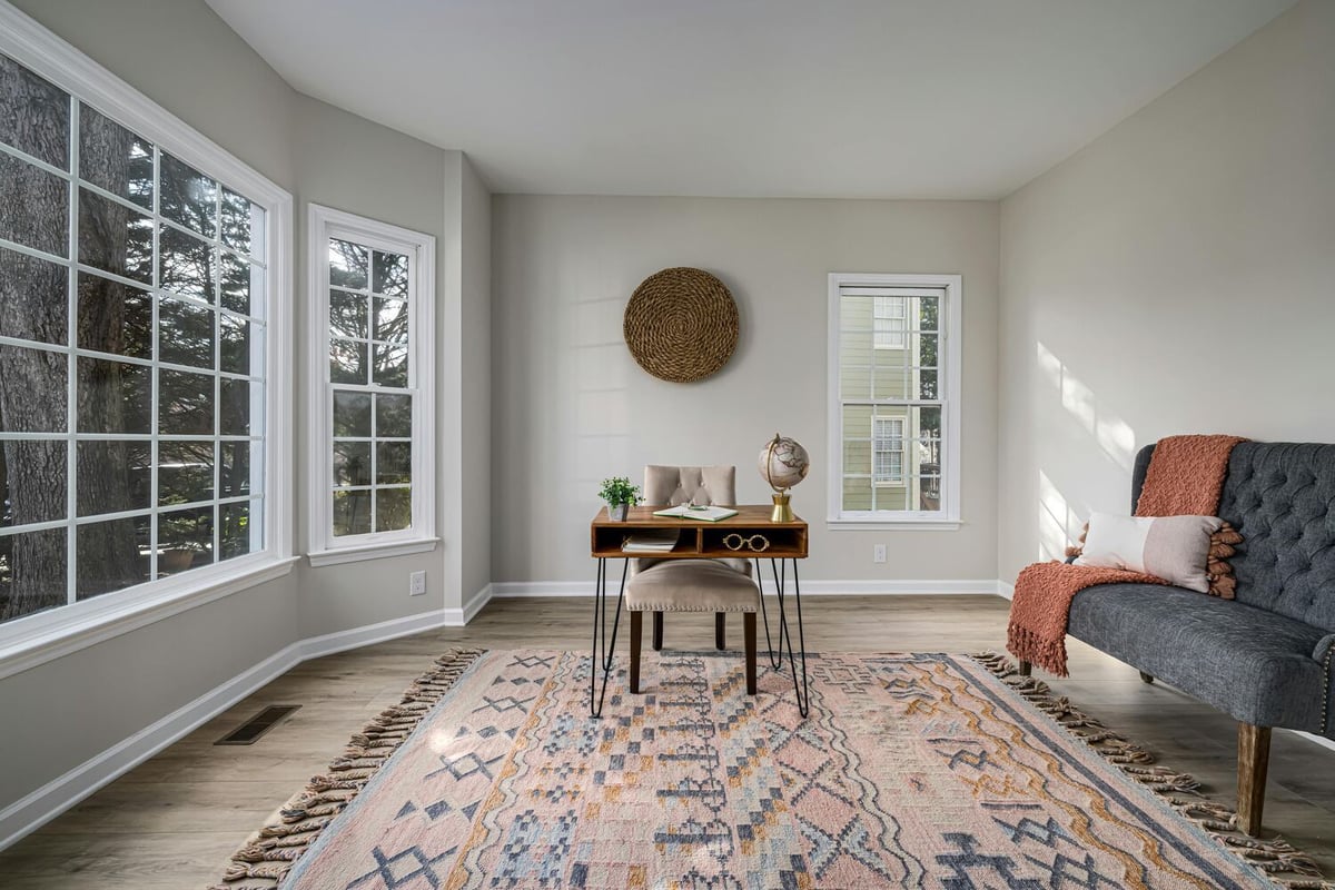 Bright home office with large corner windows and neutral finishes remodeled by Encompass Contracting in Athens, GA