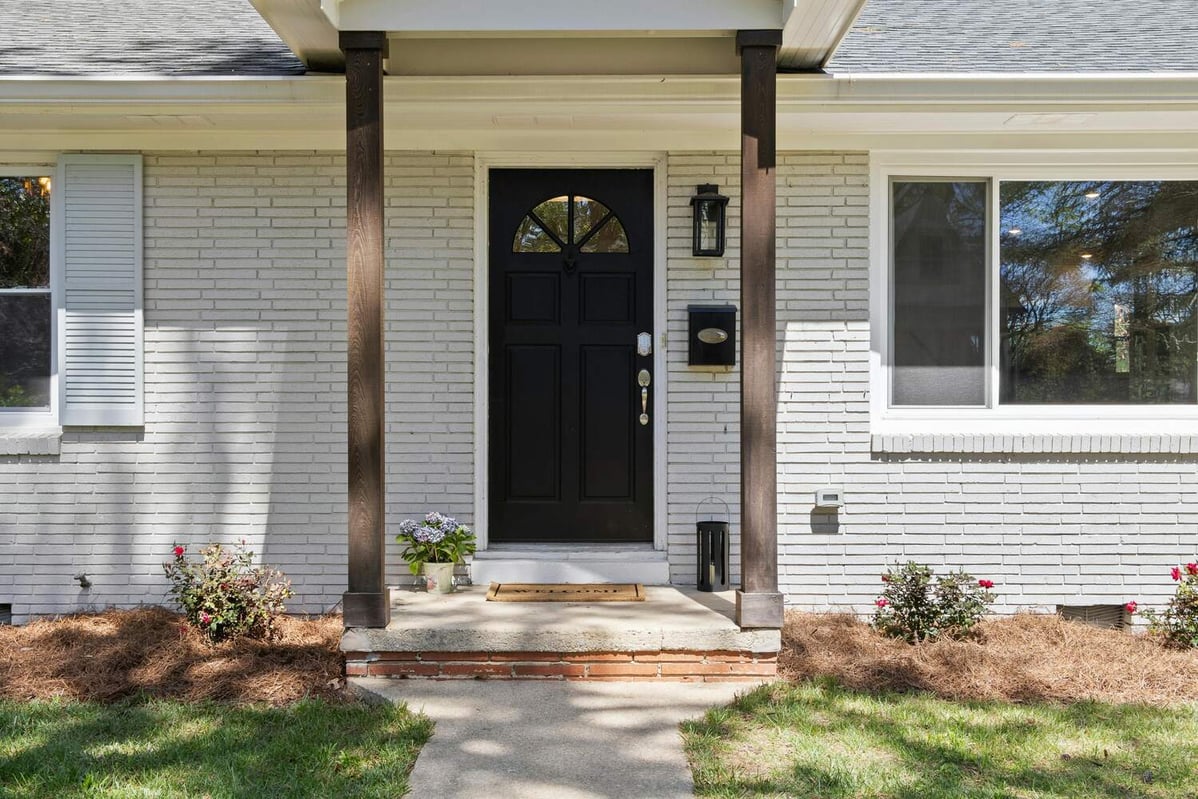 Black front door on a white painted brick home remodeled by Encompass Contracting in Athens, GA
