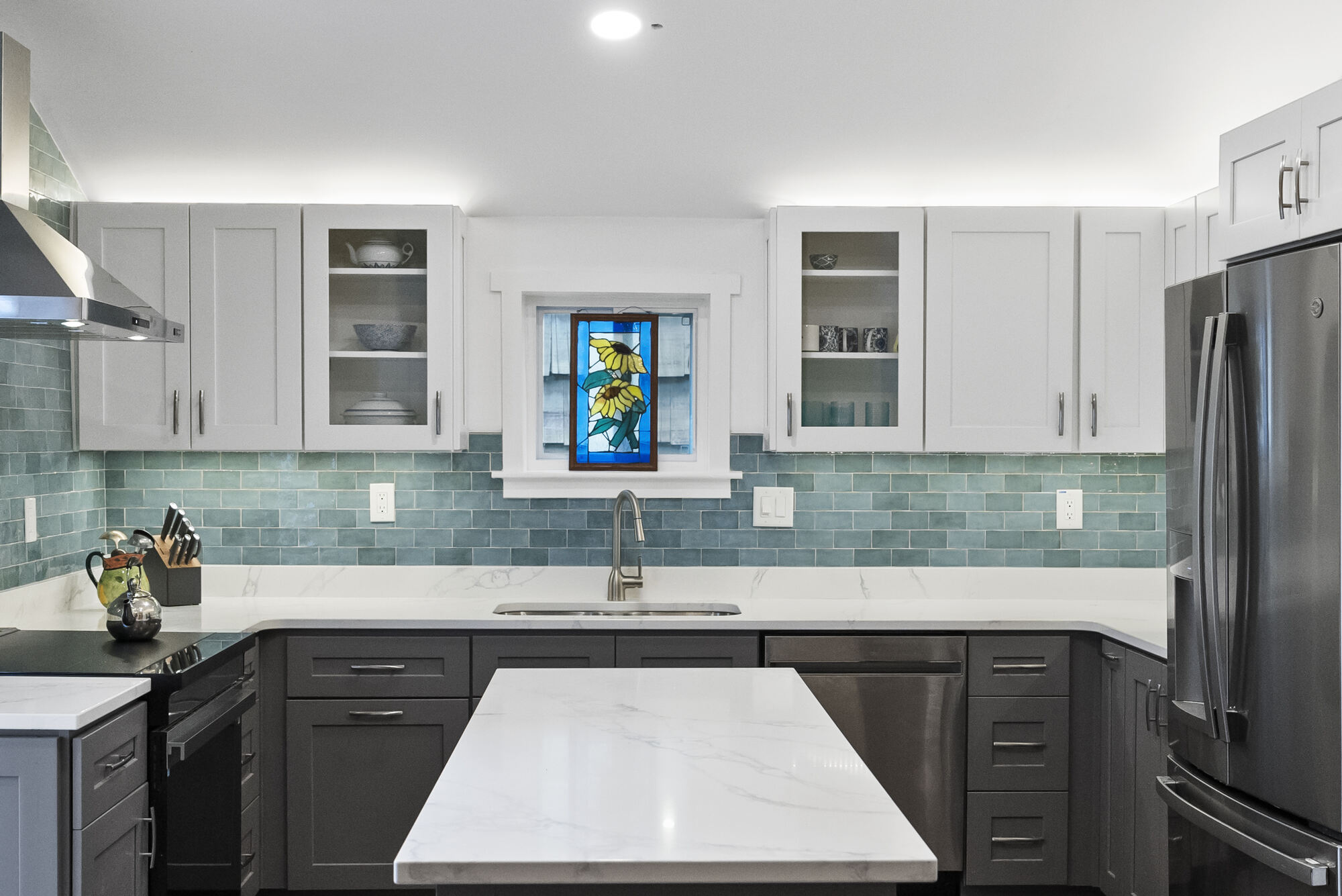 Full kitchen remodel with stained-glass window and teal backsplash by Encompass Contracting in Watkinsville, GA