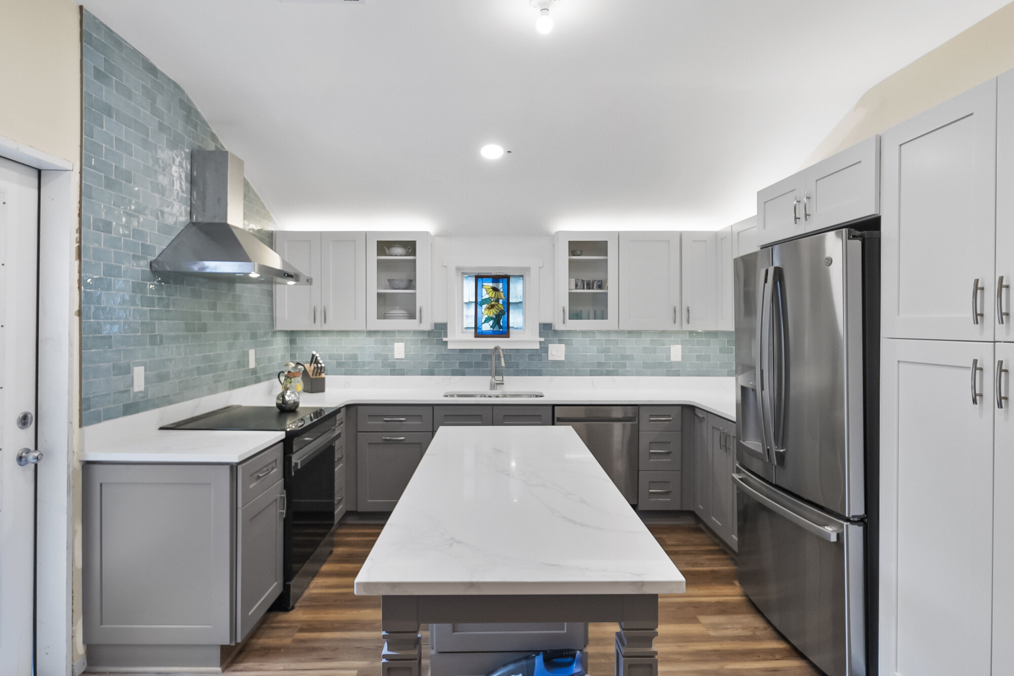 Full view of remodeled kitchen with gray cabinets and quartz island in Athens, GA by Encompass Contracting