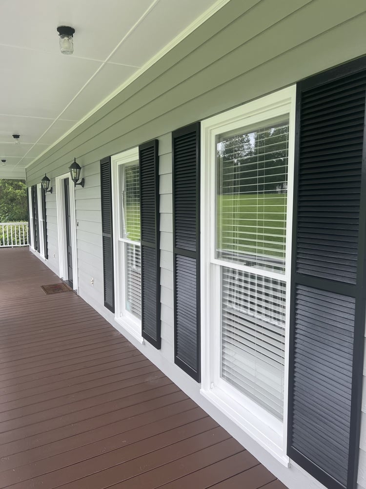 Porch detail with new gray siding and black shutters by Encompass Contracting in Bishop, GA