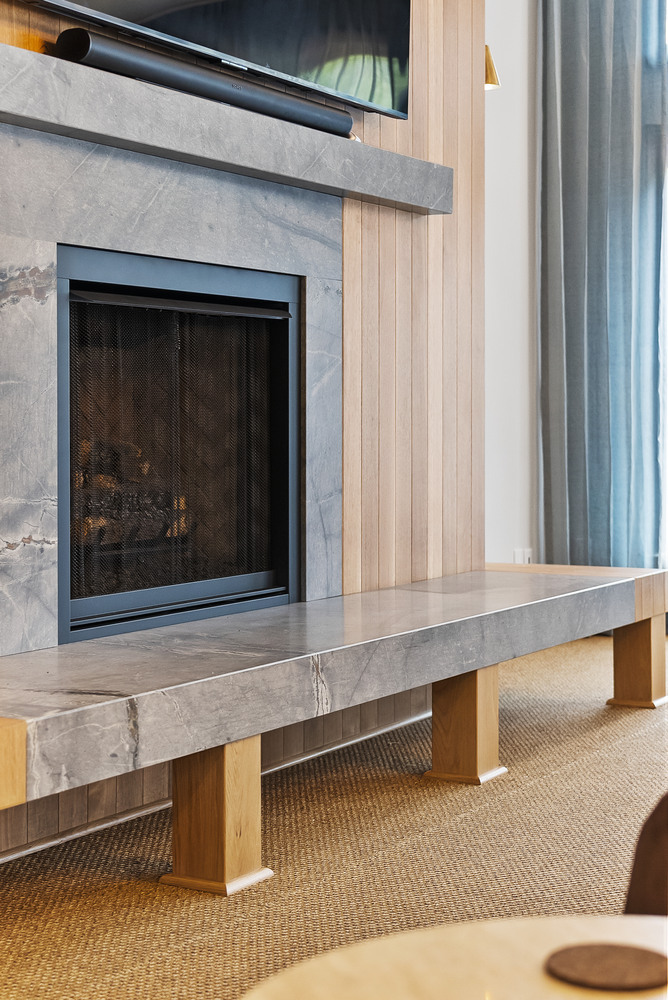 Brookhaven living room fireplace with stone surround and wood paneling by Encompass Contracting