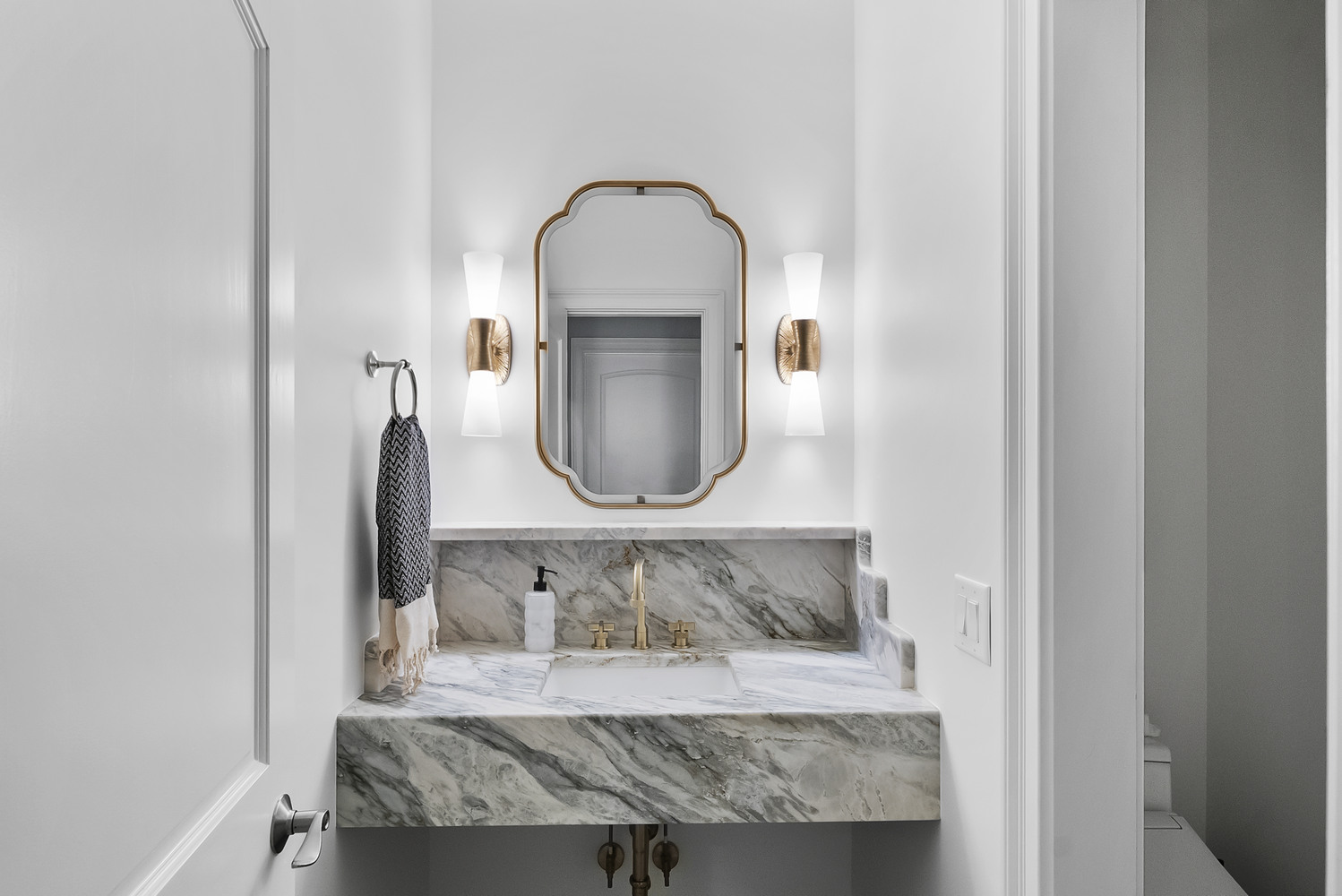 Brookhaven powder room remodel with marble countertop and gold faucet by Encompass Contracting