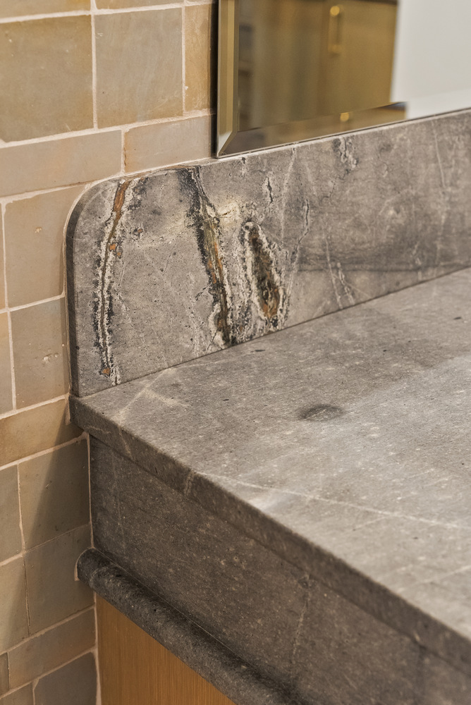 Custom stone vanity backsplash detail in Brookhaven bathroom remodel by Encompass Contracting
