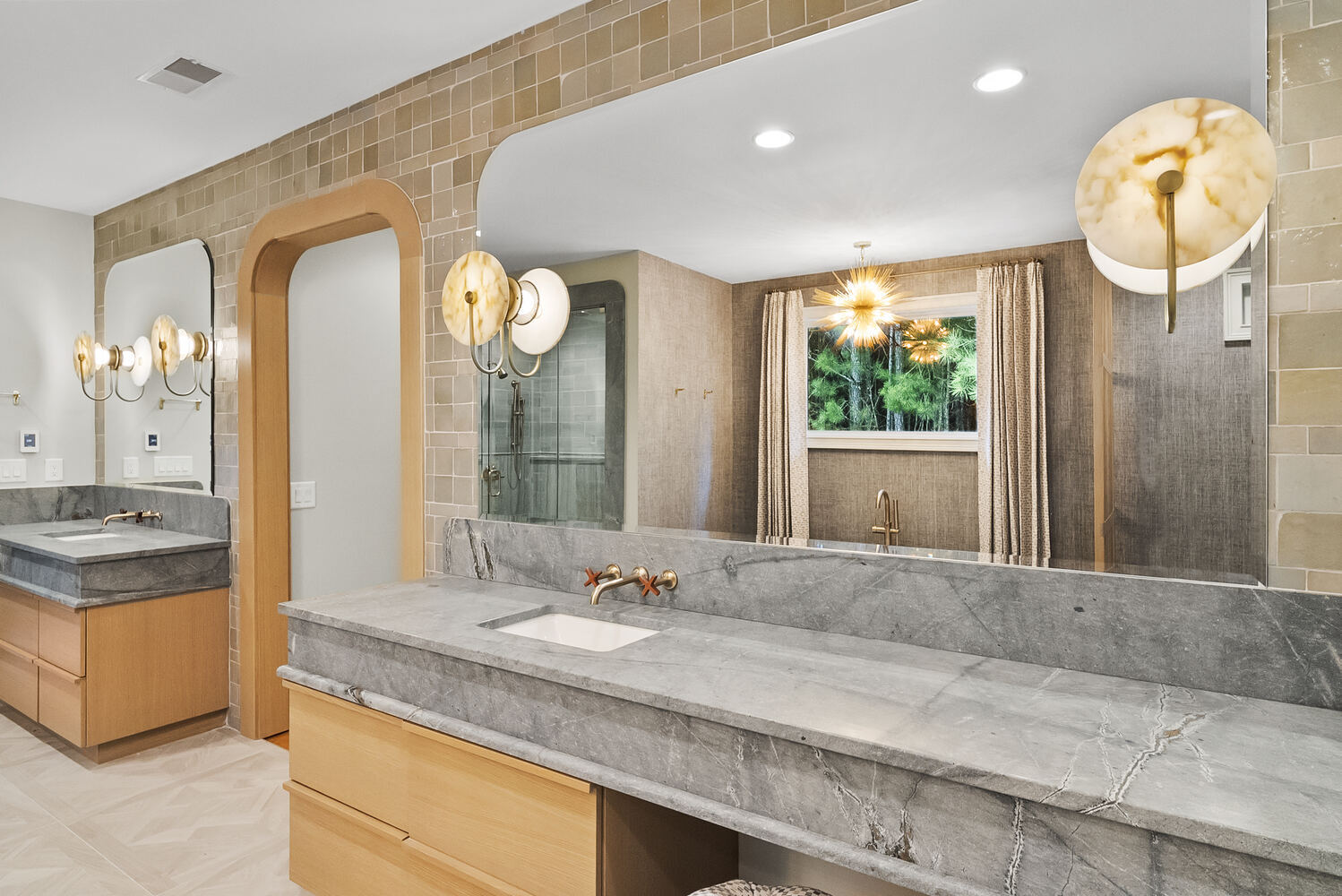 Dual vanity with stone counters and modern lighting in Brookhaven bathroom remodel by Encompass Contracting