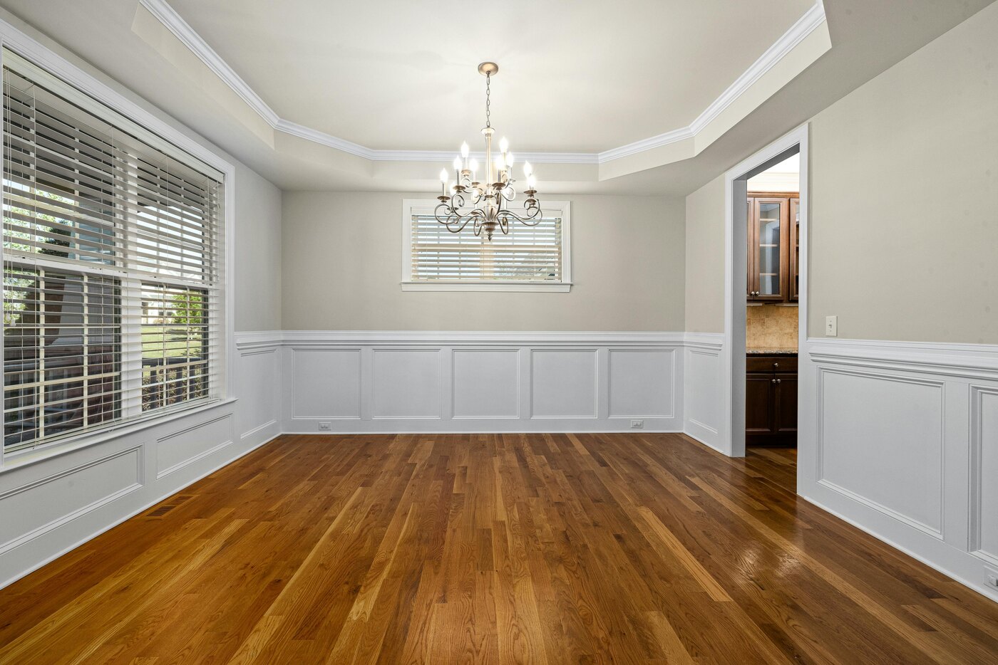 Dining room remodel with chandelier and wainscoting by Encompass Contracting in Athens, GA - stock